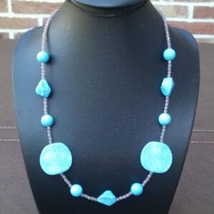 lange halsketting met turkoois geaderd kunststof kralen