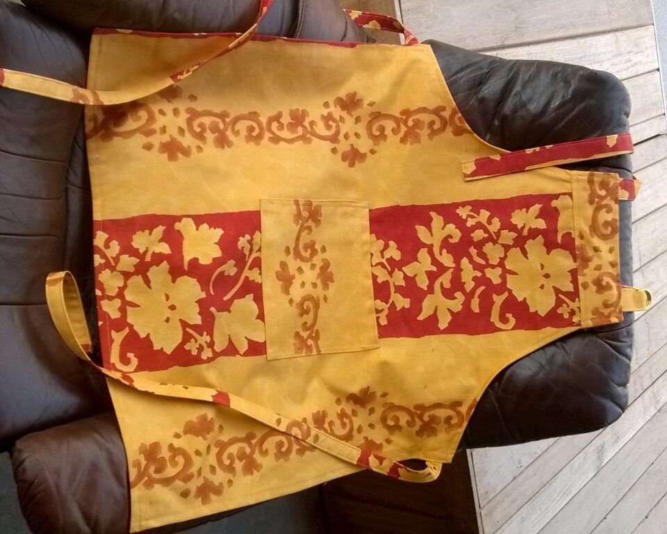 Halterschort geel rood met sierlijk bladmotief en verstelbare halsband