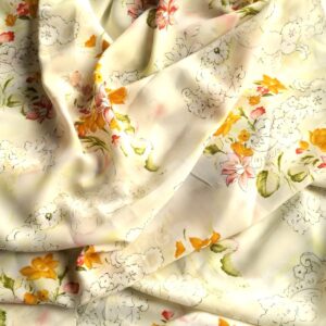 Gebloemde viscose stof licht geel met oranje en roze bloemenprint, gedrapeerd