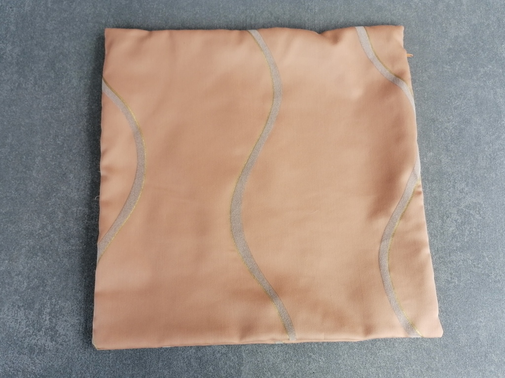 Design kussen 40x40 in bruinoranje met grijze booglijn en goudkleurige rand