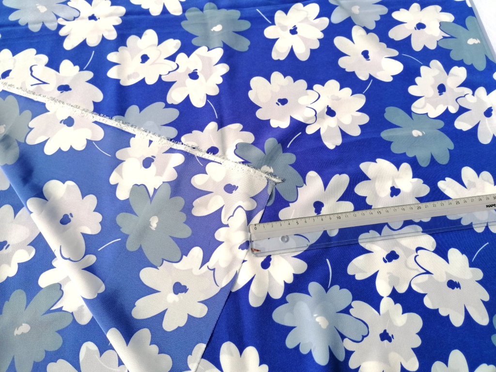 Soepele stof blauw wit gebloemd voor- en achterzijde naast elkaar, glans en printdetail vergeleken