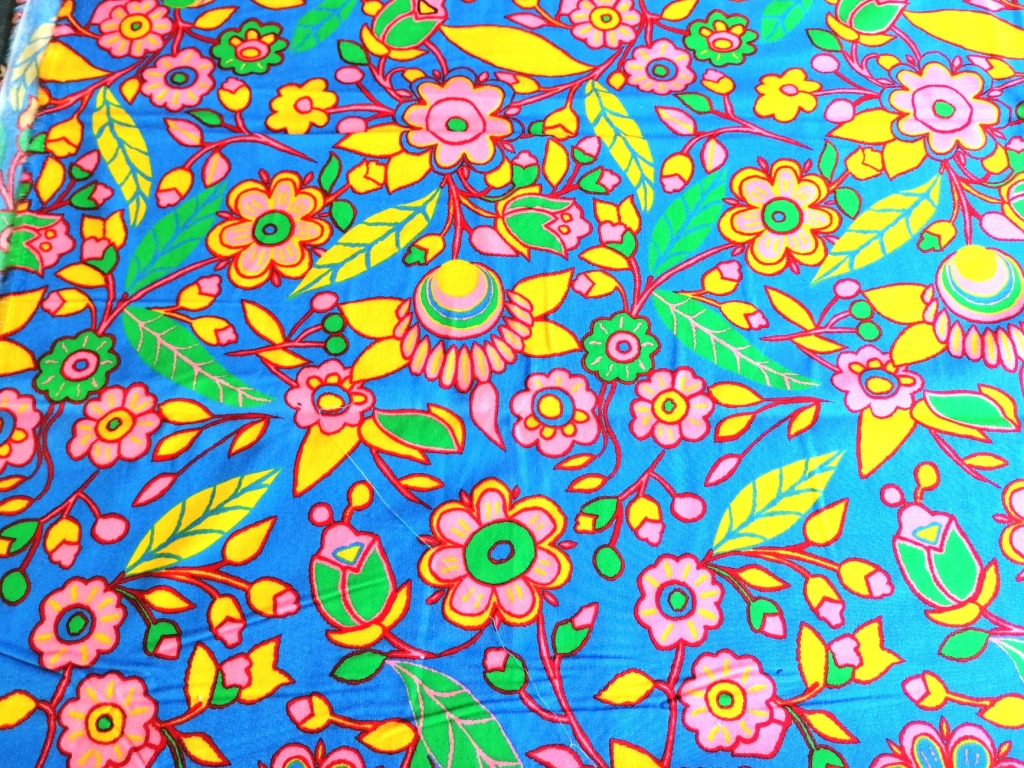 Vintage katoenen stof met frisse bloemprint — lichtblauw met gele, roze en groene bloemen.