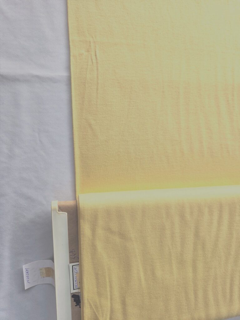 Zachtgele katoenen jersey stof met vermelding van de samenstelling