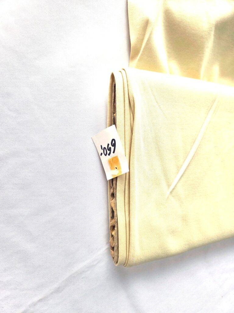 – Lichtbeige katoenen jersey stof met vermelding van de samenstelling