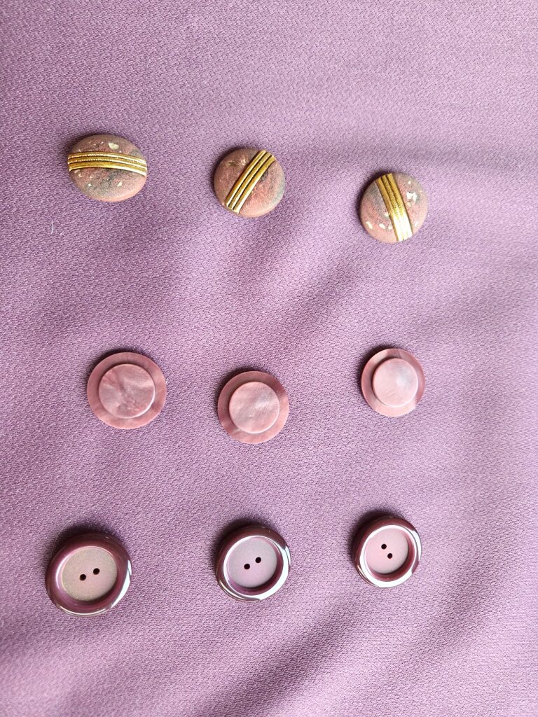 Roodpaarse combinatie met drie soorten knopen: mat roodpaars, paars blinkend en natuursteen met metaal.